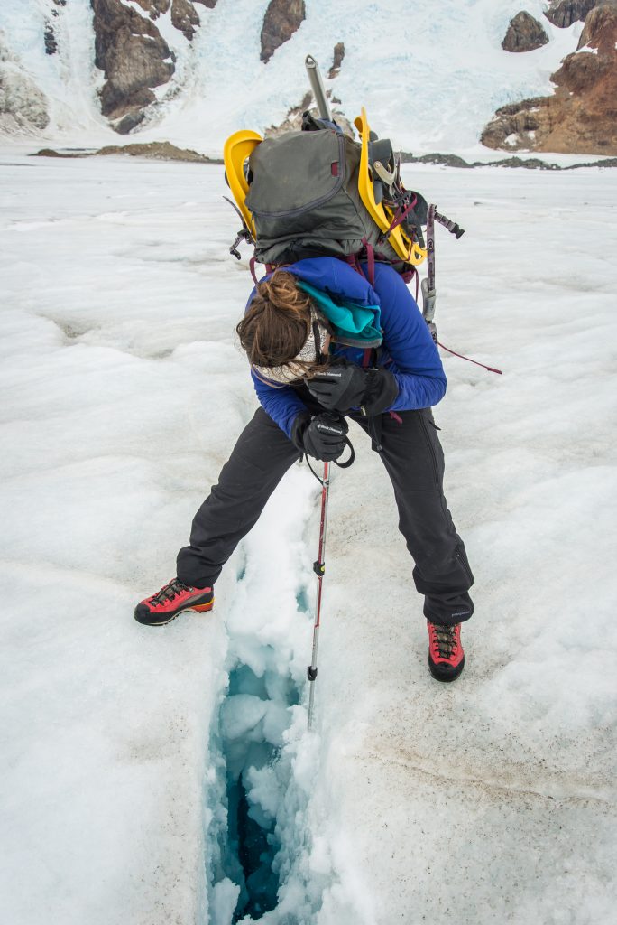 Brihannala Morgan looks down into a small crevasse.  As the annual snow melts these cracks in the ice are sometimes covered by a few inches of snow, posing an almost invisible, but very deadly hazard.